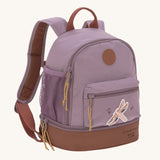 The Lassig kids mini adventure backpack in a mauve pink with a brown base, and a little dragonfly design on the front zip pocket.