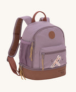 The Lassig kids mini adventure backpack in a mauve pink with a brown base, and a little dragonfly design on the front zip pocket.