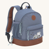 The Lassig mini backpack for kids, in a dark blue colour with a brown base and a little tractor design on the front pocket.