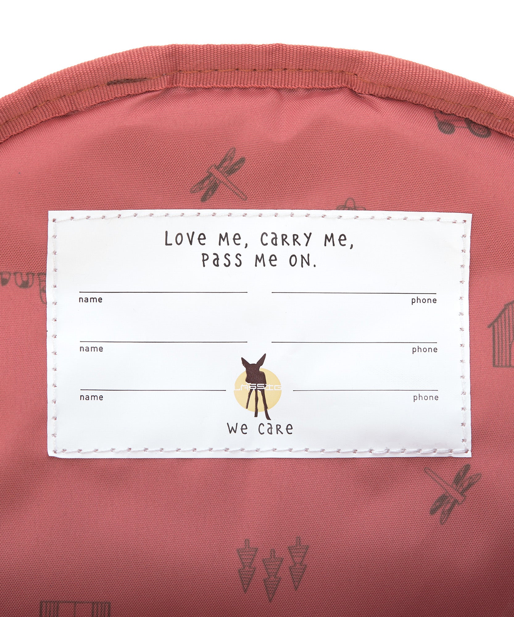 A closeup of the 'pass-me-on' name label inside the Lassig Kids mini backpack, with multiple spaces for kids to hand the bag down to younger siblings