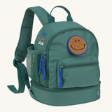 The Lassig mini backpack for kids in a dark green colour, with blue zips and a smiley face patch.