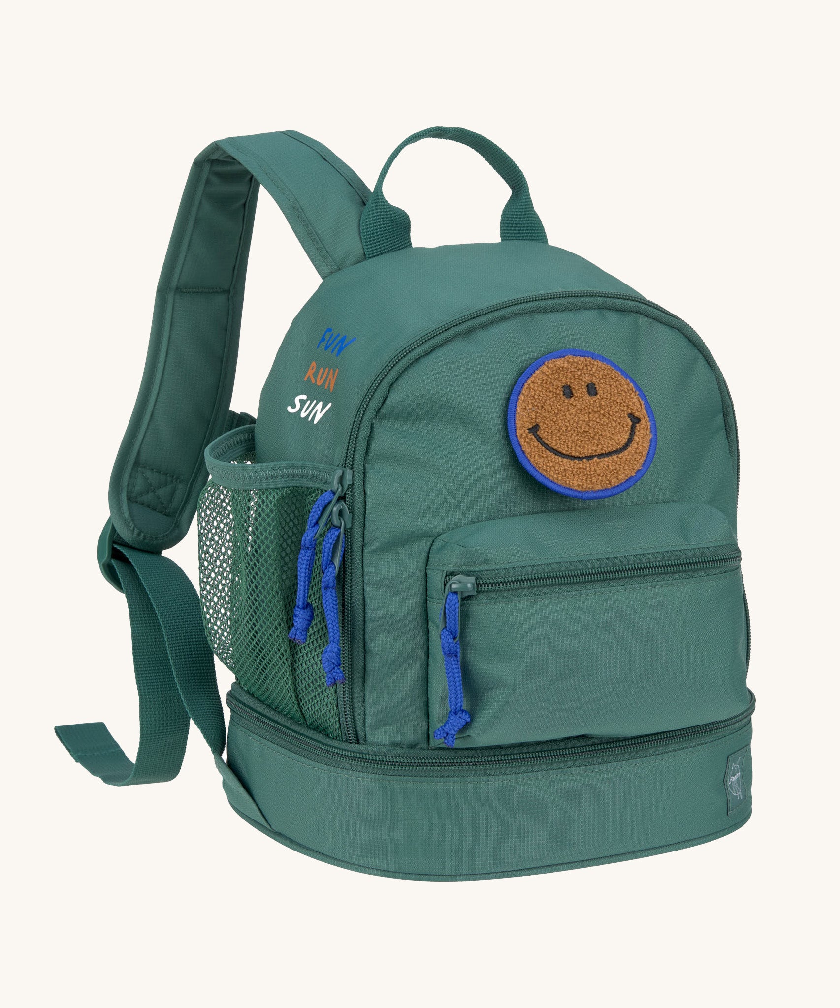 The Lassig mini backpack for kids in a dark green colour, with blue zips and a smiley face patch.