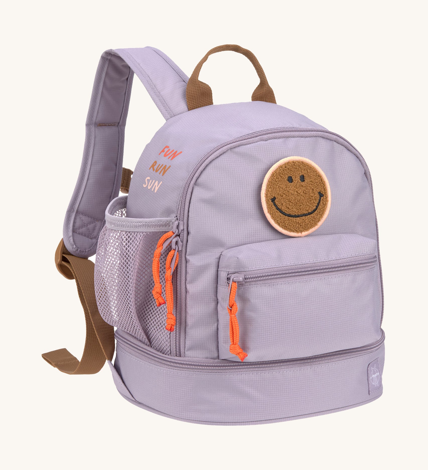 The Lassig mini kids backpack in a lilac colour with orange zips and a smiley face patch.