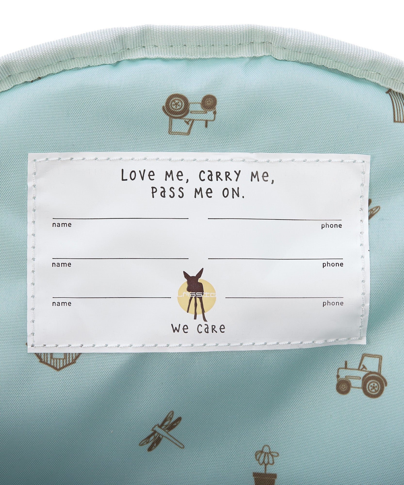 A closeup of the 'pass-me-on' name label inside the Lassig Kids mini backpack, with multiple spaces for kids to hand the bag down to younger siblings.