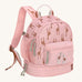 A Lassig mini backpack for kids in light pink, with giraffes printed all over.