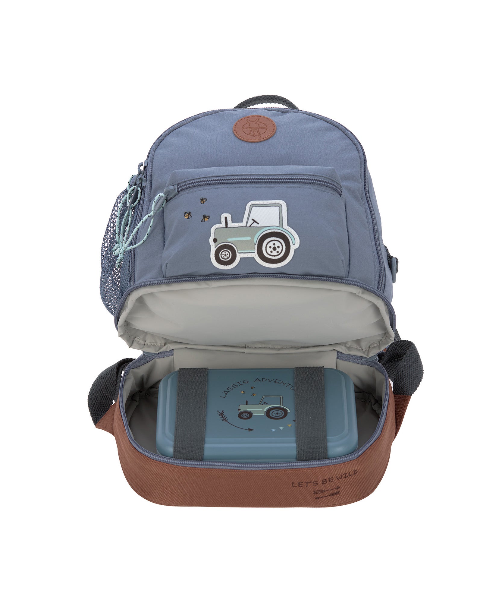 The Lassig mini backpack in blue with a tractor on the front, with the bottom zip opened so you can see the opened bottom compartment, which is storing a lunch box.