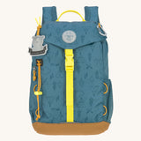 The Lassig kids mini outdoor backpack in Adventure Blue, with a print featuring tents, trees, and clouds, and a neon green front strap.