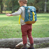 A little boy wearing the Lassig kids mini outdoor backpack in Adventure Blue.