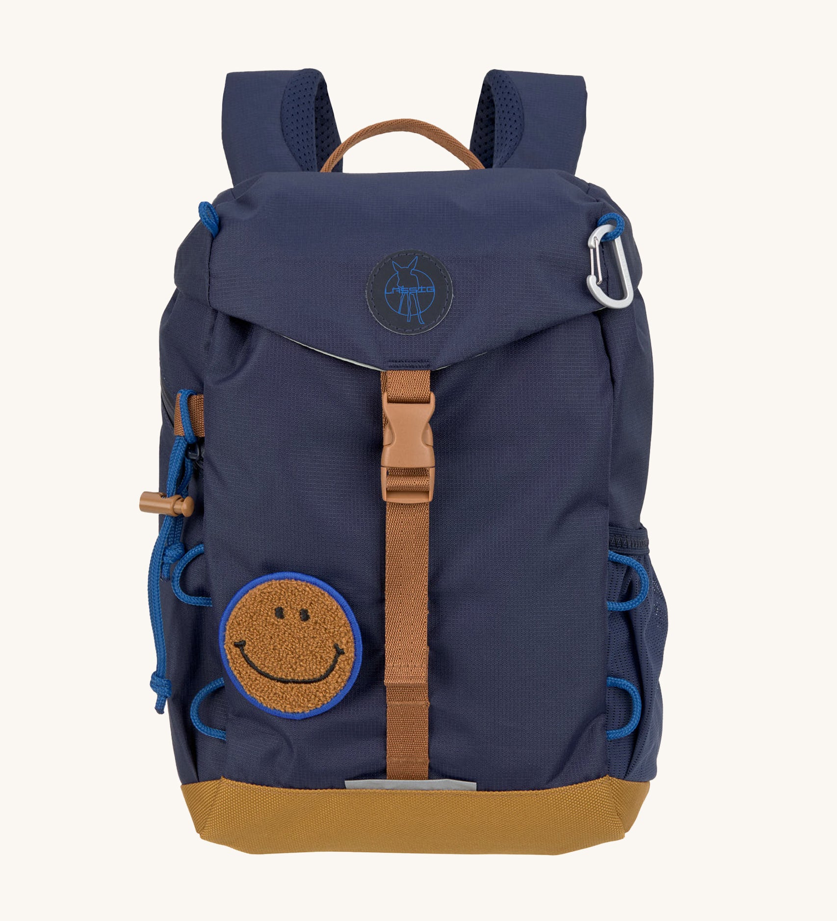 The Lassig kids mini outdoor backpack in navy blue, with a brown strap and buckle, and a smiley face patch.