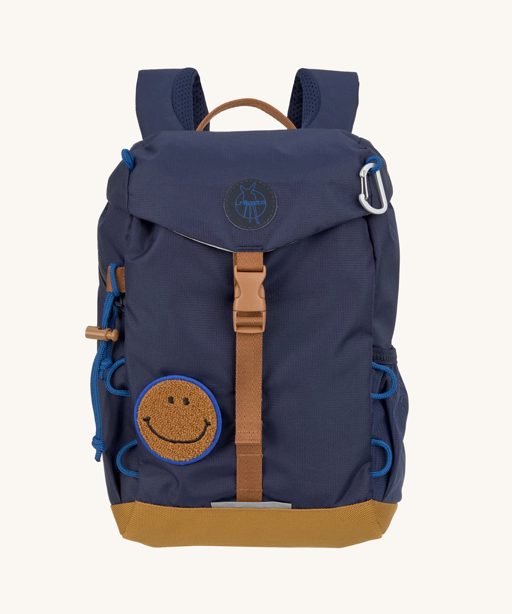 The Lassig kids mini outdoor backpack in navy blue, with a brown strap and buckle, and a smiley face patch.