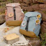 Two Lassig kids mini outdoor backpacks, one in hazelnut brown and another in light blue.