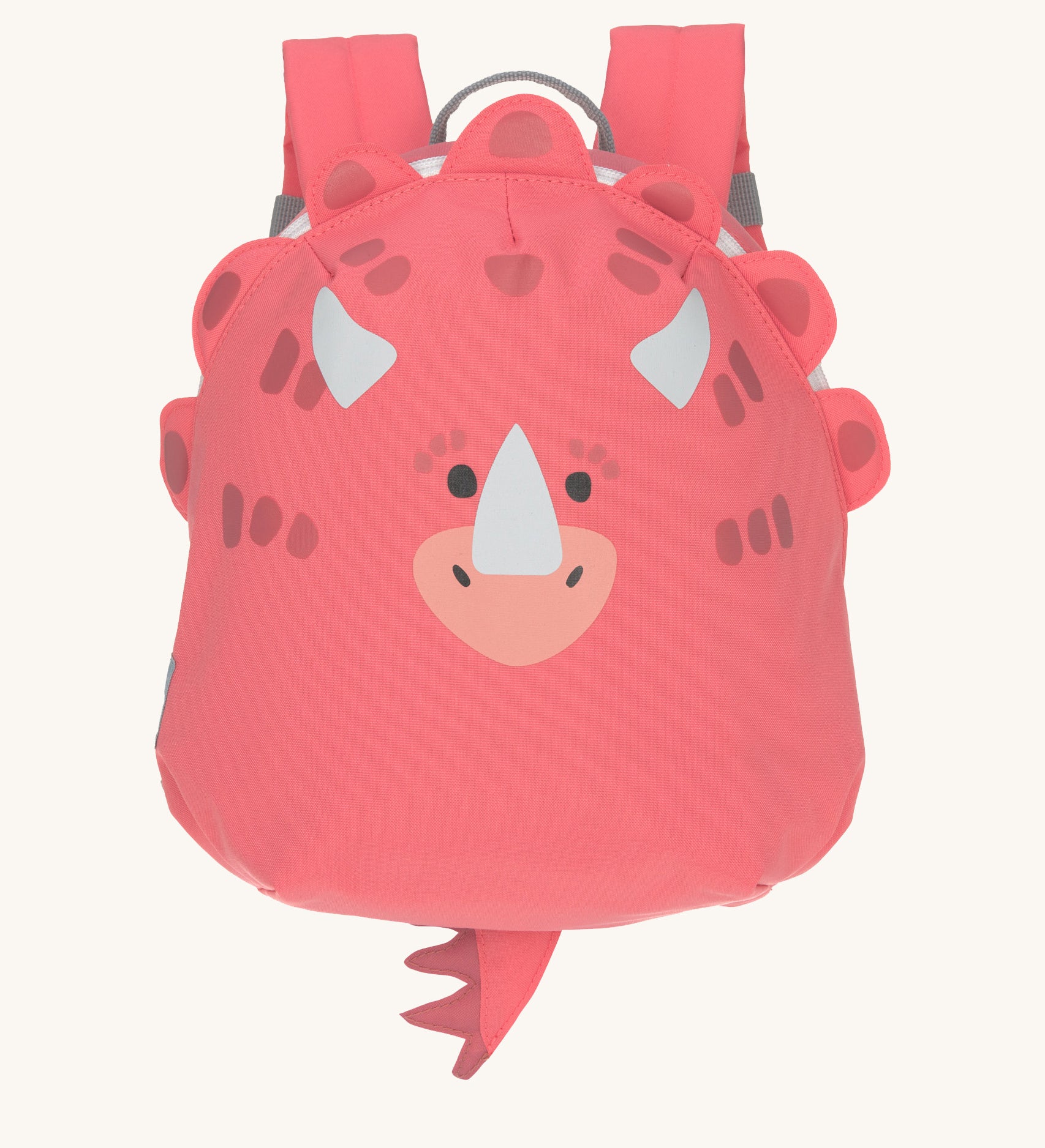 The Lassig tiny kids backpack in a bright coral pink, with a dinosaur face printed on and 3D embellishments and dino tail