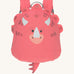 The Lassig tiny kids backpack in a bright coral pink, with a dinosaur face printed on and 3D embellishments and dino tail