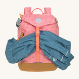 Lassig kids mini adventure backpack in rose holding a rain coat inbetween the buckle fastener.