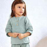 A little girl wearing the Lassig organic cotton muslin long sleeved shirt for babies and toddlers, in a silver grey
