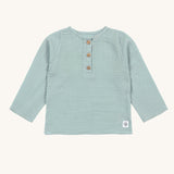 The Lassig organic cotton muslin long sleeved shirt for babies and toddlers, in a silver grey with three little brown buttons.