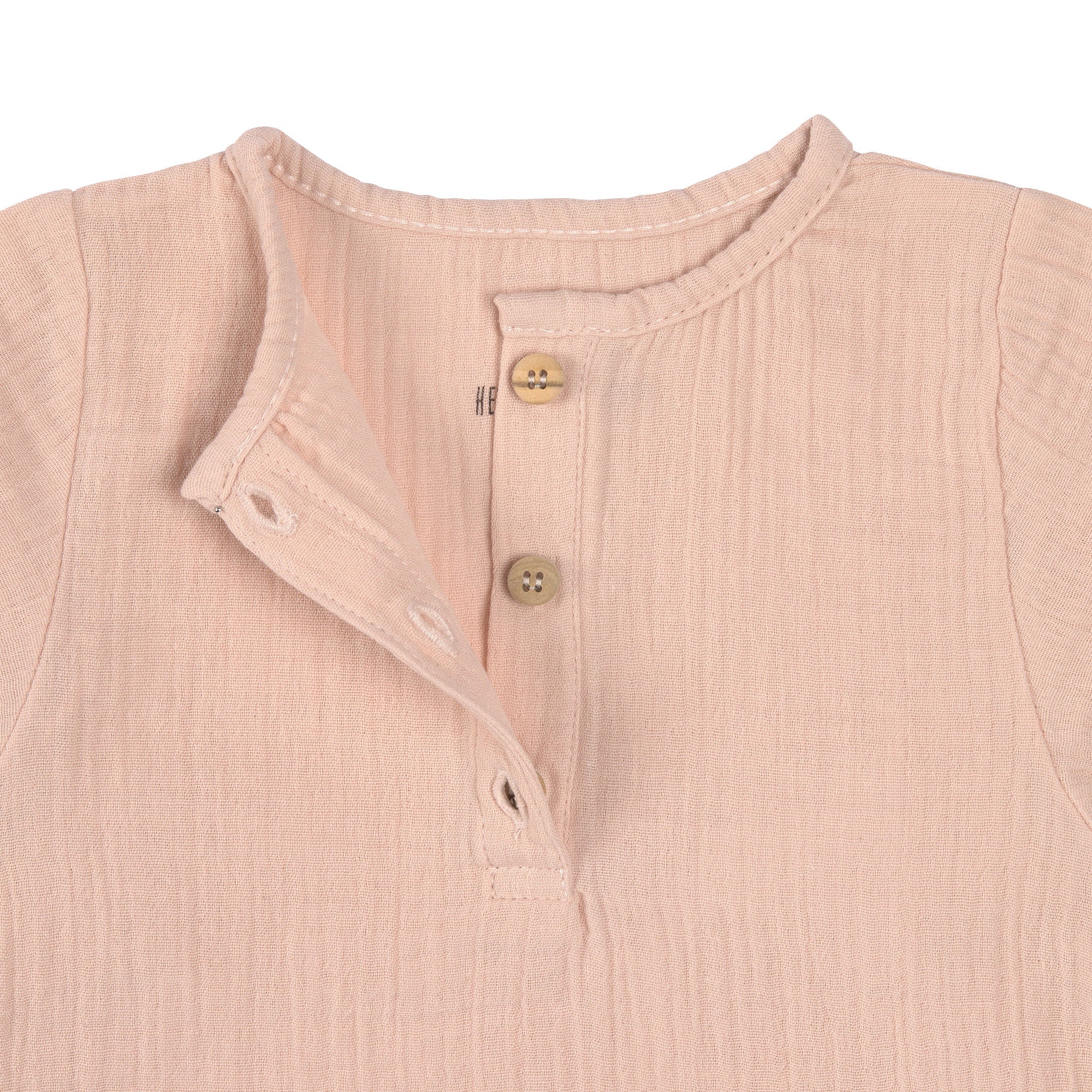 The Lassig organic cotton muslin long sleeved top for babies and toddlers, in a beautiful pale powder pink colour. Close up image shows the three small brown buttons.