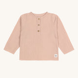 The Lassig organic cotton muslin long sleeved top for babies and toddlers, in a beautiful pale powder pink colour with little buttons.