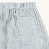 A closeup of the back pocket on the Lassig organic cotton muslin baby pants, in powder blue.