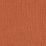 A closeup of the lovely organic cotton muslin fabric in orange rust.