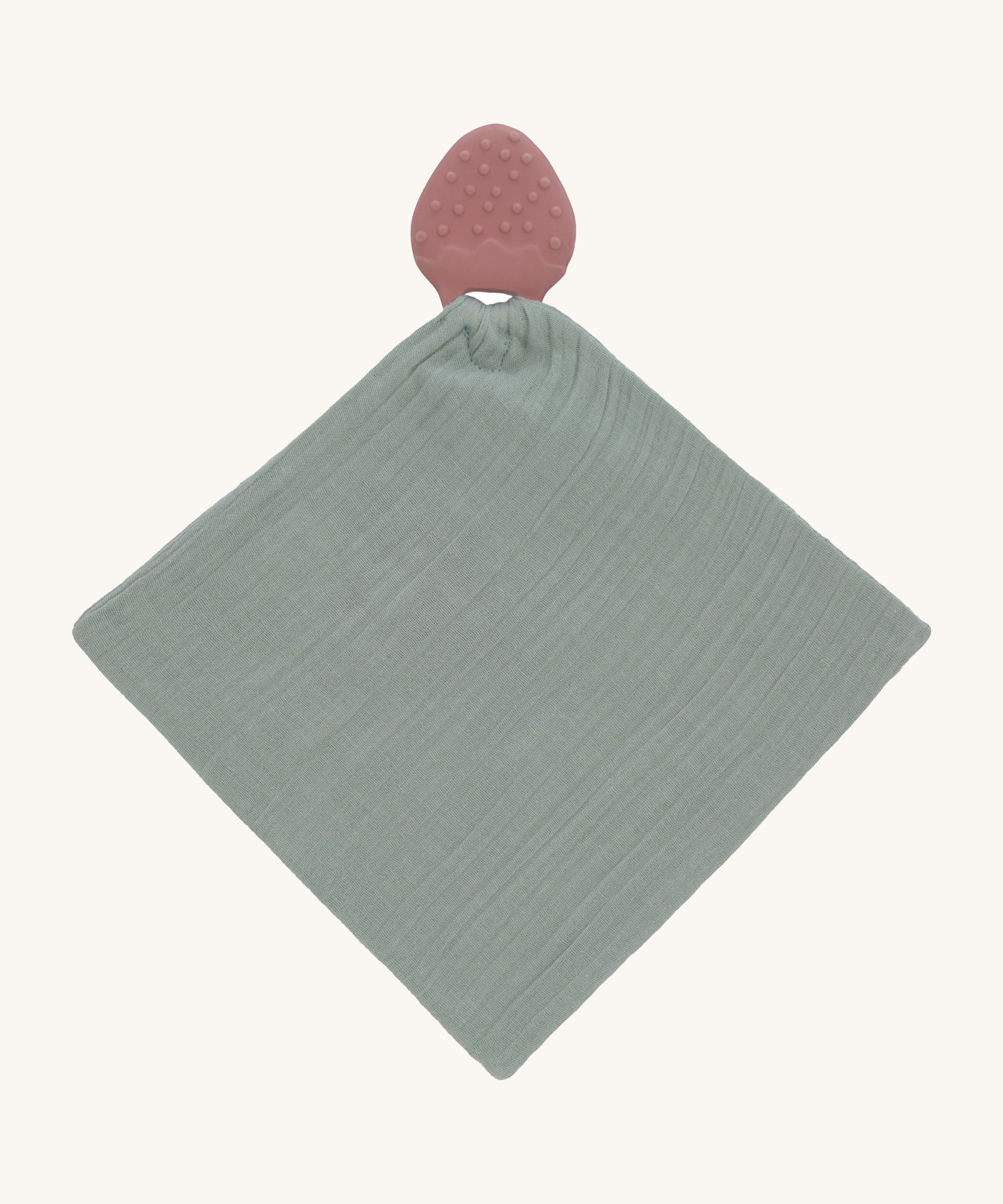 The Lassig organic cotton muslin comforter in green, with a strawberry shaped rubber teether attached to the top.
