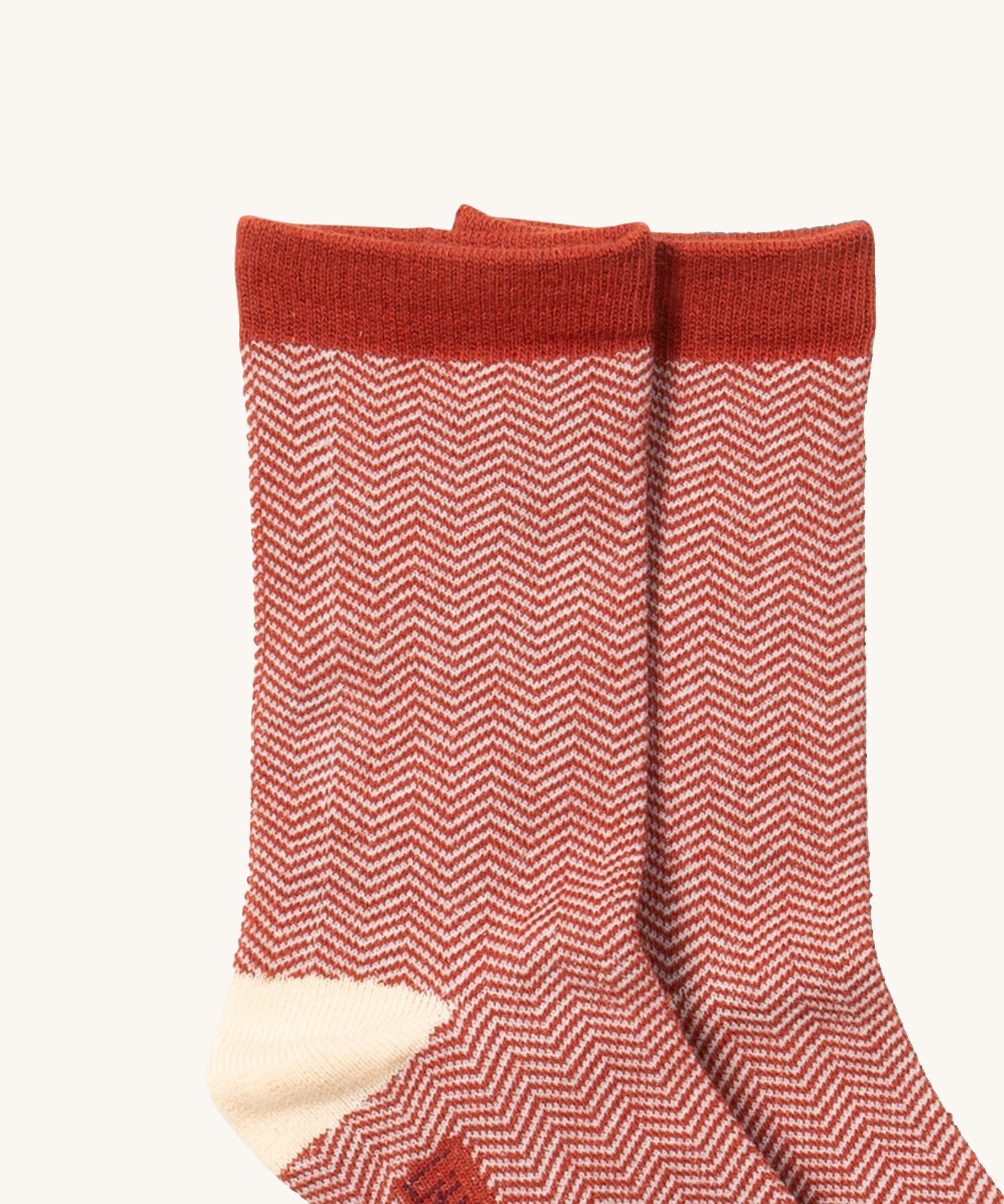 A close up of the Little Green Radicals brown striped ankle showing the zig zag striped detail on organic cotton fabric with light brown and cream trim.