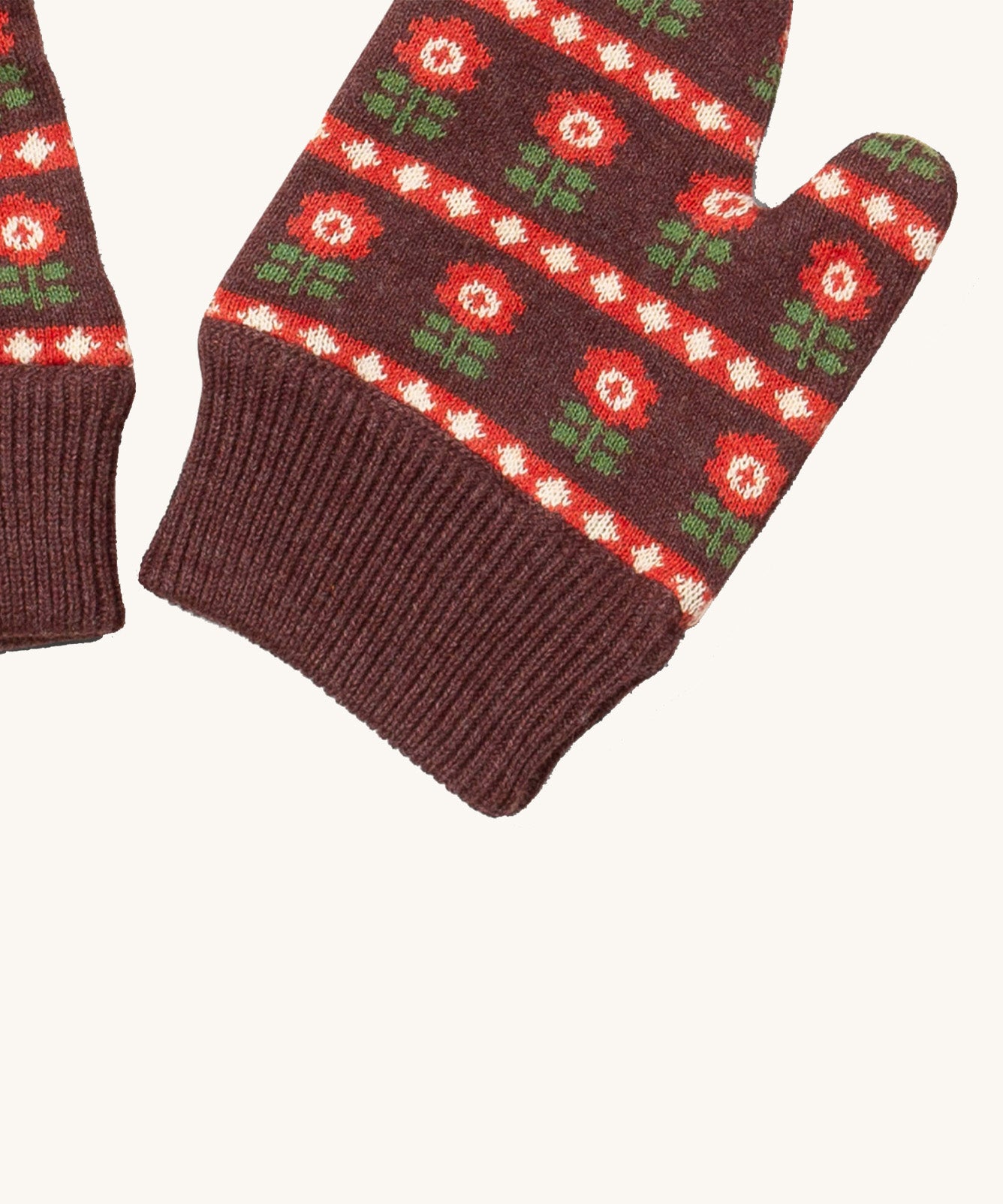A close up of the Little Green Radicals collecting flowers mittens showing the retro red flower design and matching brown elasticated cuff detail on organic cotton fabric