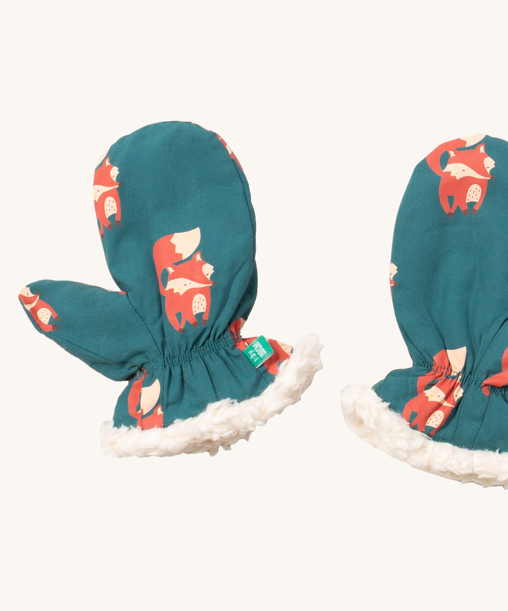 A close of the Little Green Radicals sherpa fleece mittens in foxes. Showing a close up of the fox print and white sherpa fleece detail on turquoise organic cotton fabric.