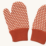 A close up of the Little Green Radicals ginger diamond mittens showing the dark orange and cream diamond design on organic cotton fabric