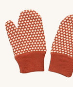 A close up of the Little Green Radicals ginger diamond mittens showing the dark orange and cream diamond design on organic cotton fabric