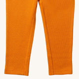 A close up of the Little Green Radicals golden waffle leggings showing the leg cuff detail and the waffle texture on yellow organic cotton fabric.