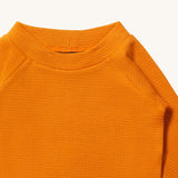 A close up of LGR Long Sleeve Waffle Top - Golden Ochre showing the waffle texture and collar detail on yellow organic cotton fabric