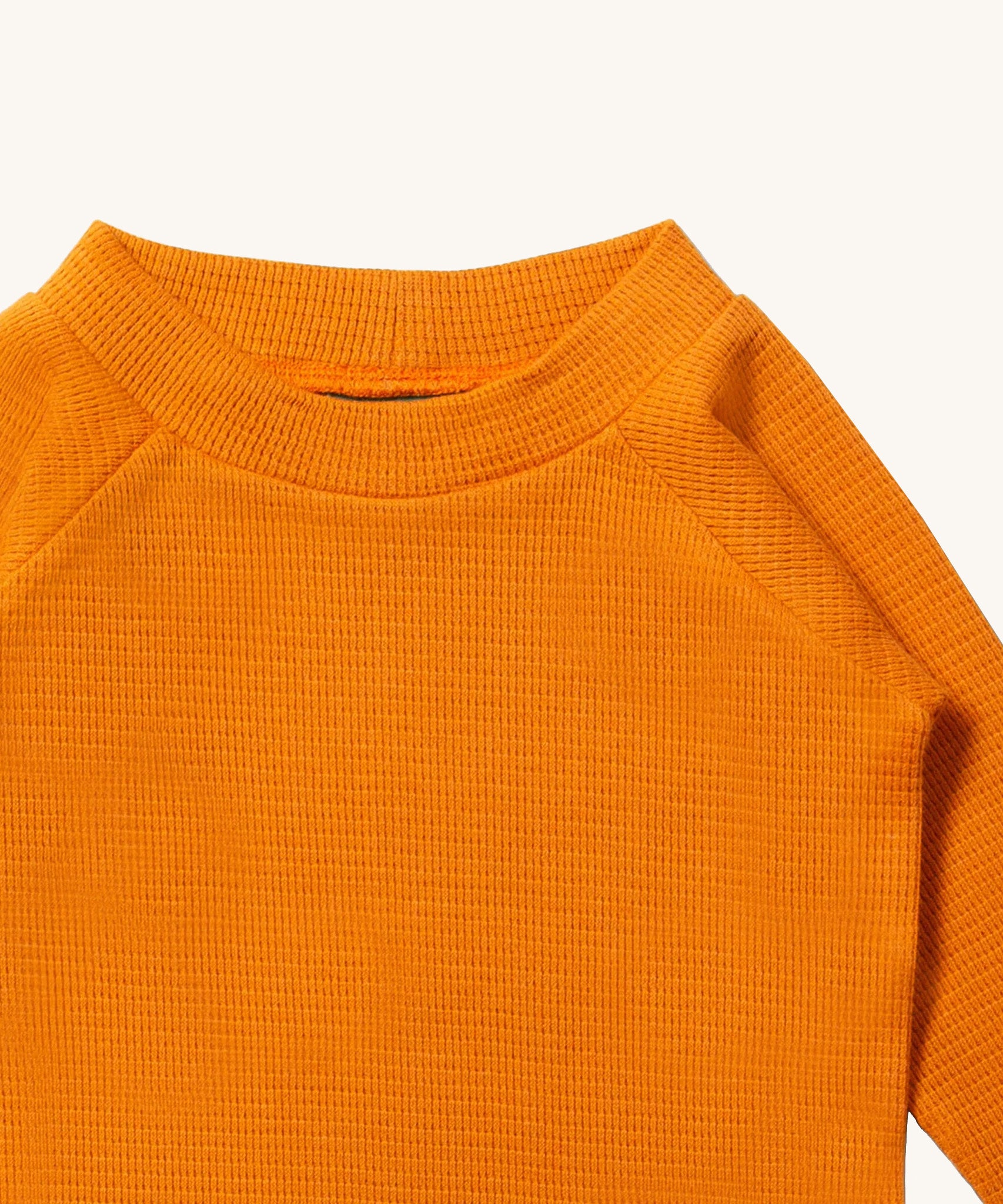 A close up of LGR Long Sleeve Waffle Top - Golden Ochre showing the waffle texture and collar detail on yellow organic cotton fabric