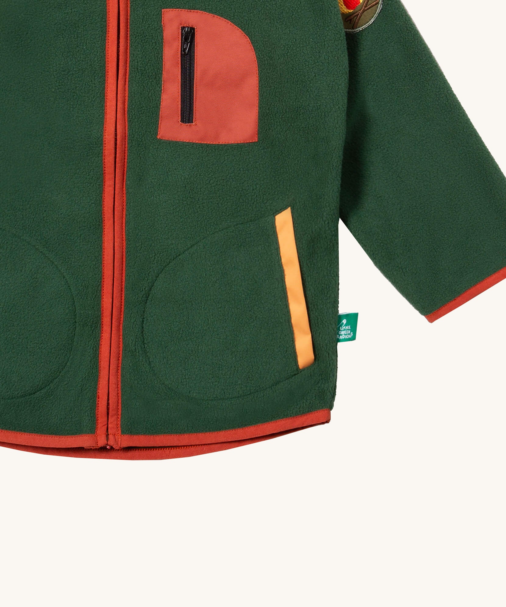A close up of the Little Green Radicals polar fleece jacket in olive showing the chest and pocket detail and a close up of the camp fire appliqué patch on the shoulder.