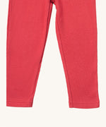 A close up of the Little Green Radicals pink berry waffle leggings showing the waffle knit and leg cuff detail on pink organic cotton fabric