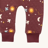 A close up of the Little Green Radicals flying birds quilted joggers. Showing the quilted stitch and elasticated leg cuff detail on dark maroon organic cotton fabric.