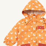 A close up of the Little Green Radicals waterproof adventure coat in gold ducks showing the sherpa fleece liner under the hood, the full length zip and 2 side pockets in red trim detail on yellow recycled polyester fabric