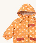 A close up of the Little Green Radicals waterproof adventure coat in gold ducks showing the sherpa fleece liner under the hood, the full length zip and 2 side pockets in red trim detail on yellow recycled polyester fabric