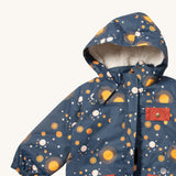 A close up of the Little Green Radicals waterproof adventure coat in night moon showing the sherpa fleece liner, the full length zip and 2 side pockets in red trim detail on navy recycled polyester fabric