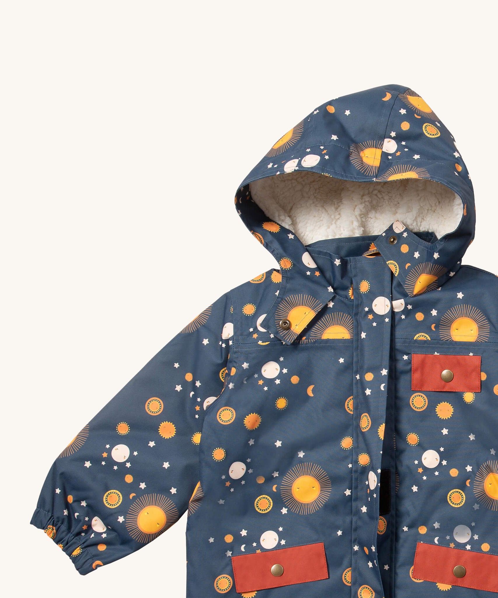 A close up of the Little Green Radicals waterproof adventure coat in night moon showing the sherpa fleece liner, the full length zip and 2 side pockets in red trim detail on navy recycled polyester fabric