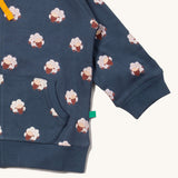 A close up of the Little Green Radicals reversible easy rider jacket in sleeping sheep. Showing the pouch pocket detail and a close up of the sheep print on navy GOTS organic cotton fabric