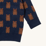 A close up of the Little Green Radicals navy teddy bears knitted jumper showing the cute brown bear detail and thick cuff detail on navy organic cotton fabric.