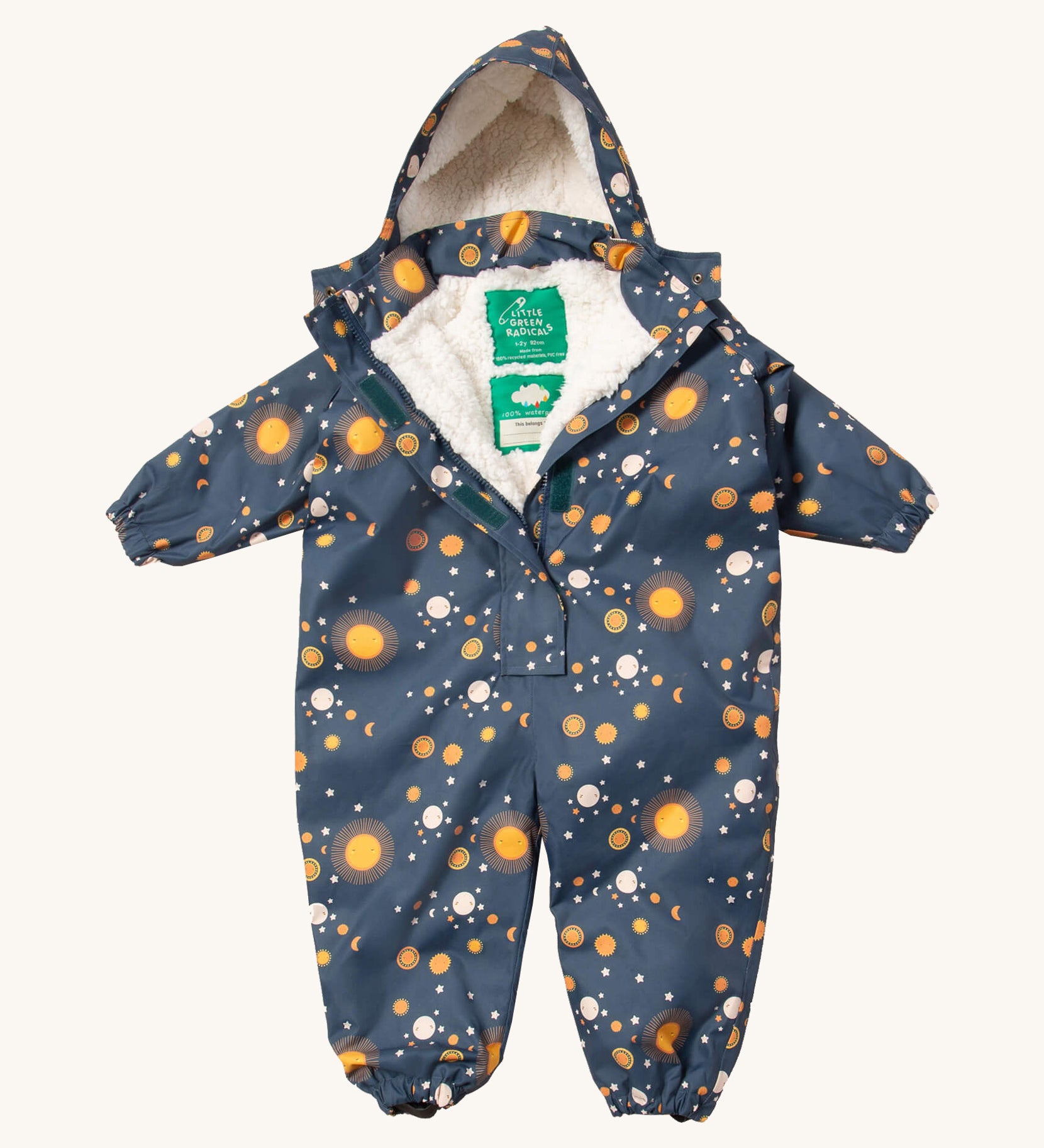 Little Green Radicals night moon waterproof winter suit  available at Babipur. A recycled polyester thick all in one outfit in navy with a cute starry night print. Features a hood, a white sherpa fleece inner liner, elasticated cuffs and black straps on the legs to go over footwear.