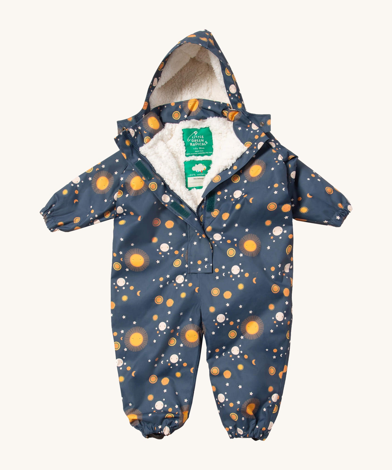 Little Green Radicals night moon waterproof winter suit  available at Babipur. A recycled polyester thick all in one outfit in navy with a cute starry night print. Features a hood, a white sherpa fleece inner liner, elasticated cuffs and black straps on the legs to go over footwear.