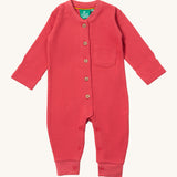 Little Green Radicals holly pink berry waffle playsuit available at Babipur. A GOTS organic cotton all in one in a waffle style. Features button fasteners on the front and poppers around the crotch with a small pouch chest pocket