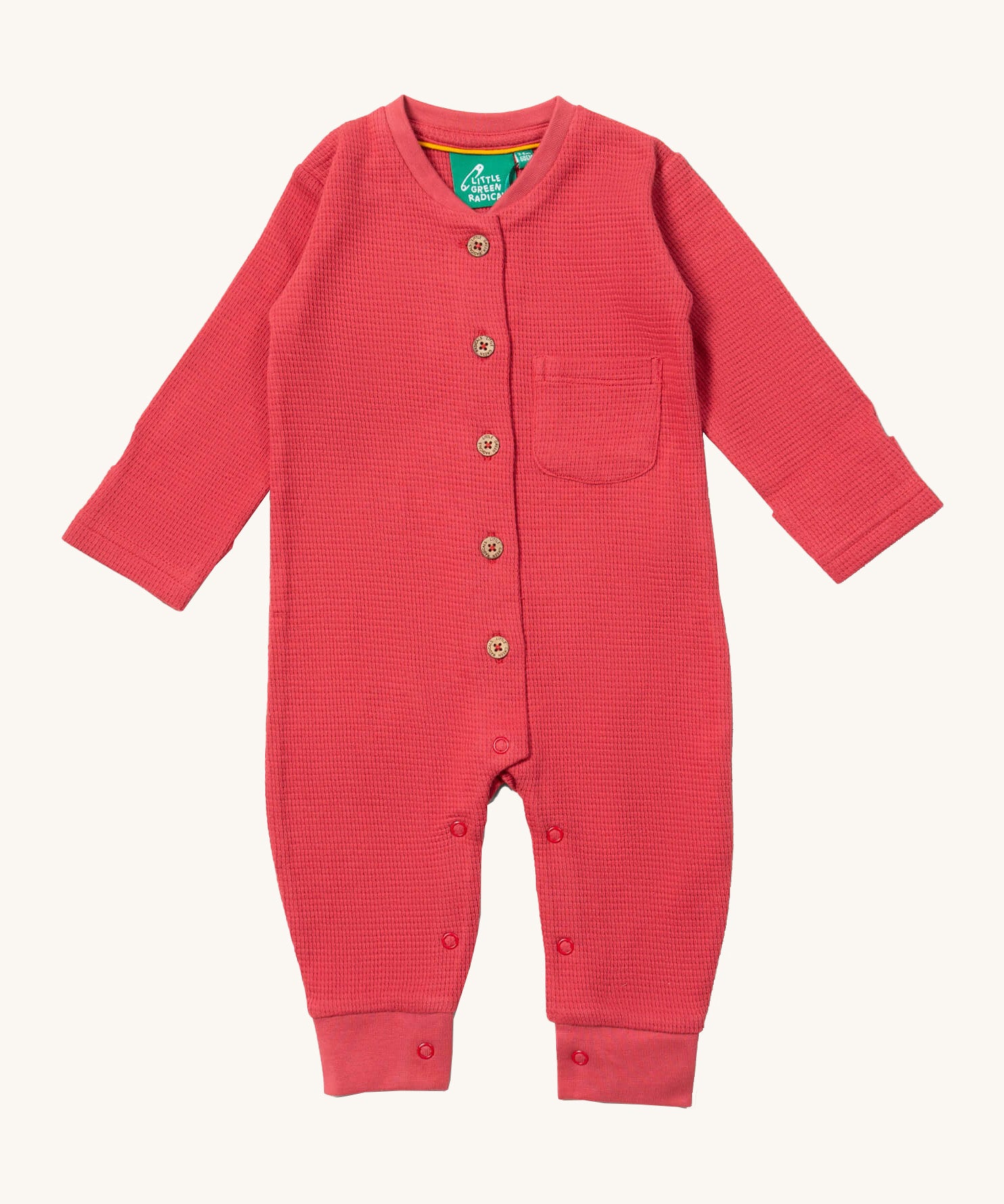Little Green Radicals holly pink berry waffle playsuit available at Babipur. A GOTS organic cotton all in one in a waffle style. Features button fasteners on the front and poppers around the crotch with a small pouch chest pocket