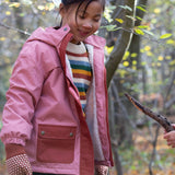 Two children playing with a stick while wearing little green radicals coats
