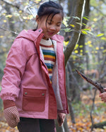Two children playing with a stick while wearing little green radicals coats