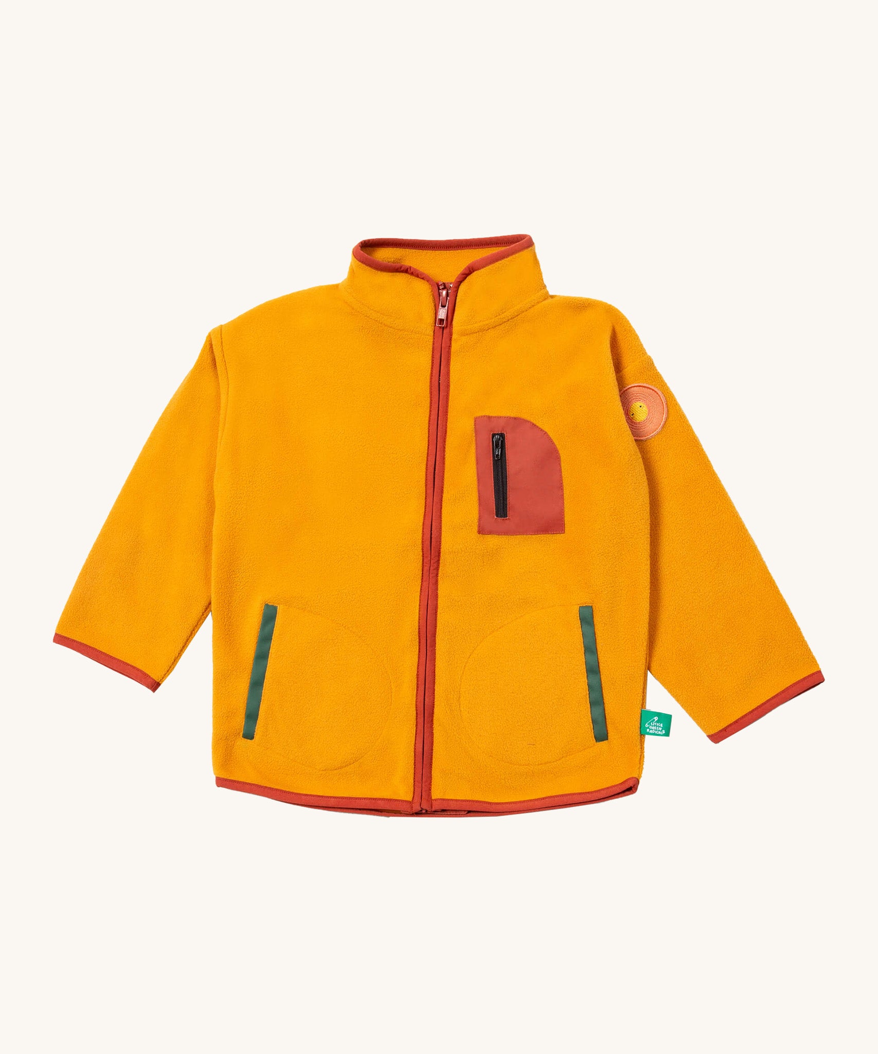 Little Green Radicals polar fleece jacket in gold available at Babipur. A dark yellow recycled polyester fleece with red trim. Features a chest and 2 side pockets and a sun appliqué patch on the left shoulder