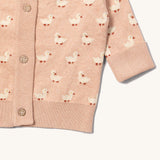 A close up of the Little Green Radicals knitted cardigan in puddle ducks showing the button detail and a close up of the white cuff and hem detail on soft pink GOTS organic cotton fabric and available at Babipur.